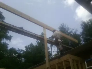 Carpenter setting a ridge beam over a new addition frame — Ice Dam Removal by Roofing Brothers in Carlisle